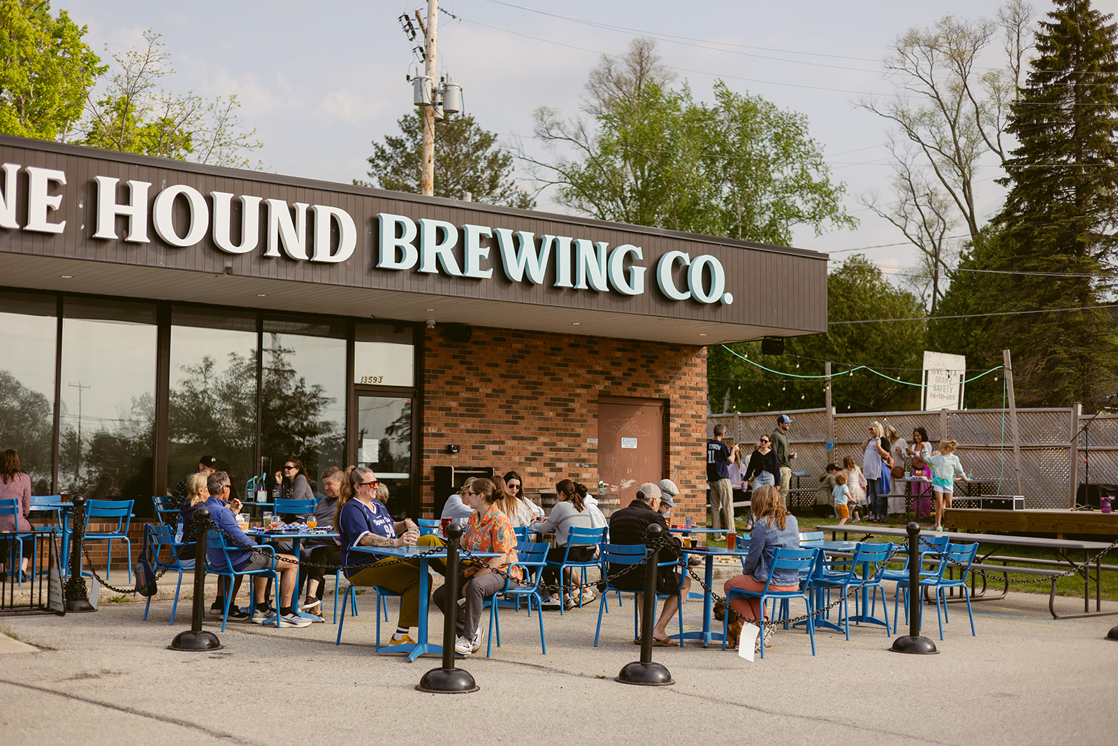 A lively outdoor community patio scene at Stone Hound Brewing Co. right next to the TART Trail path