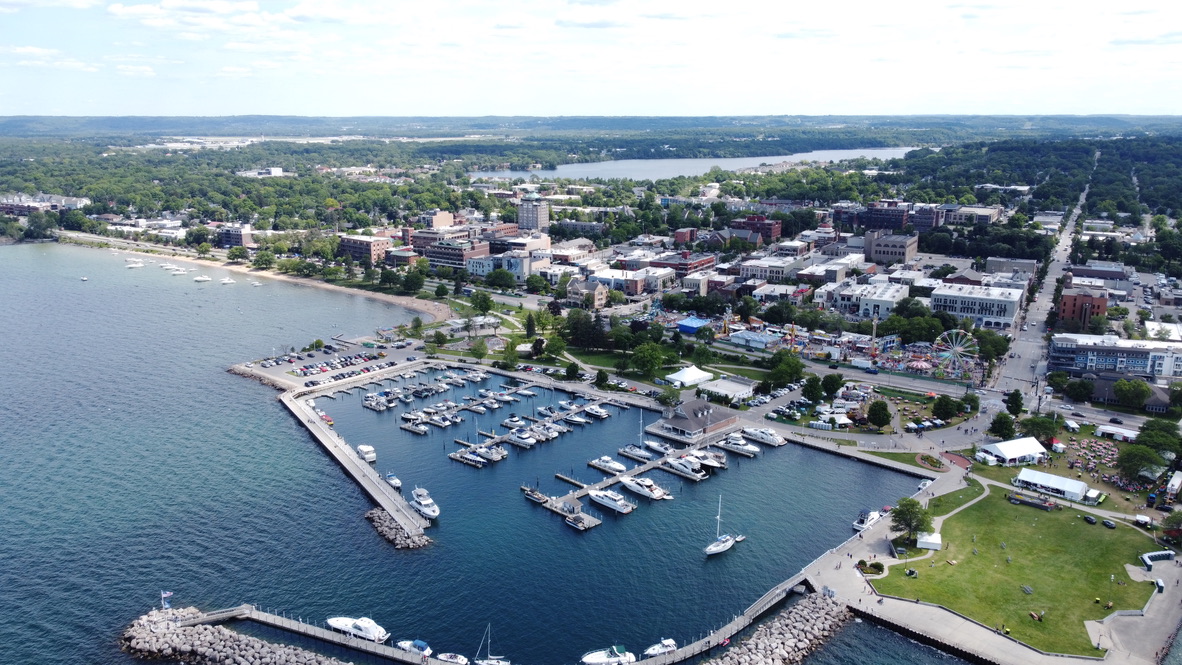 Aerial view of downtown Traverse City, the marina, and the beach along West Grand Traverse Bay in summer