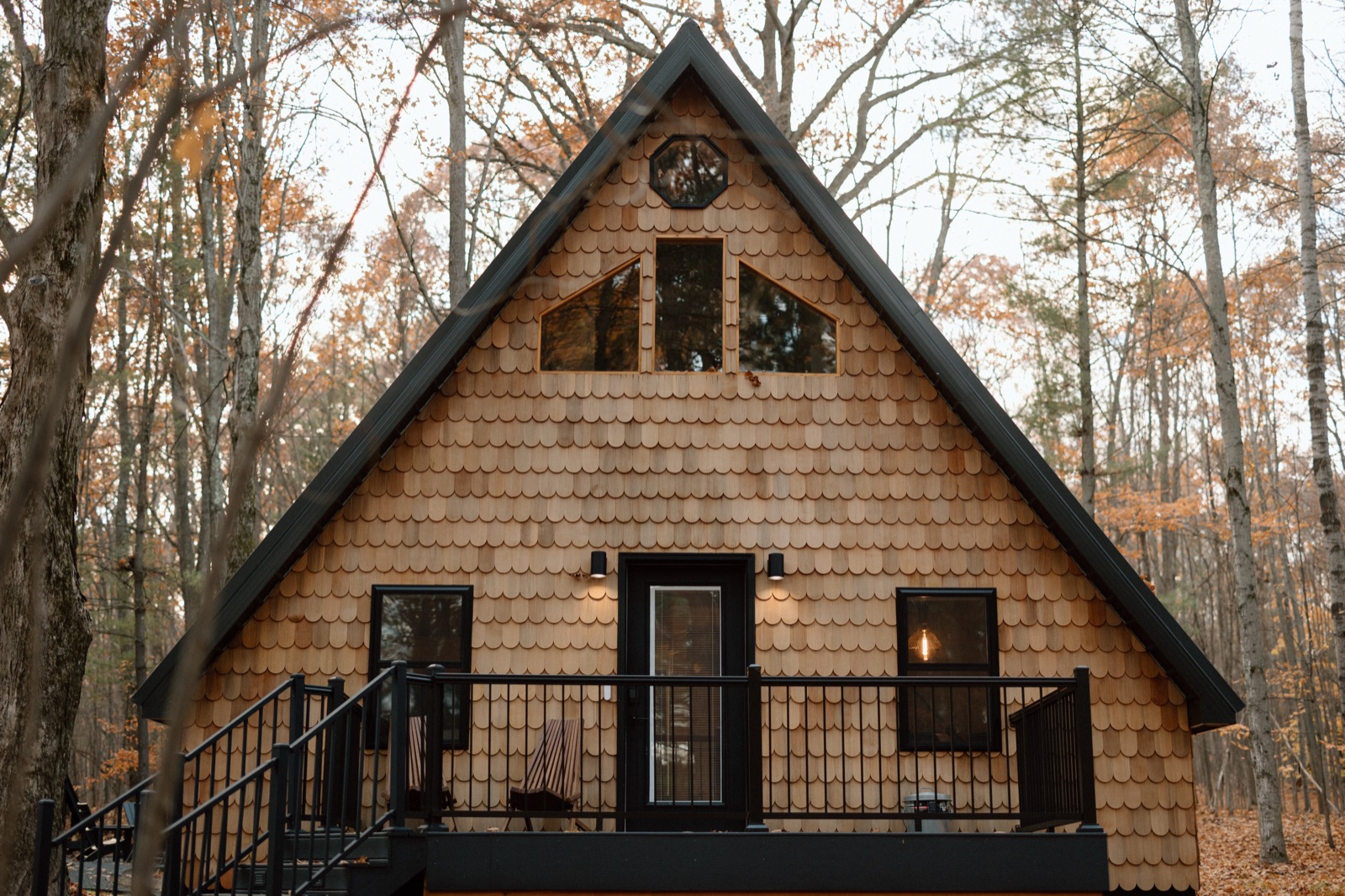 A-frame cabin with cedar shake siding among golden fall trees near Lake Ann, Michigan